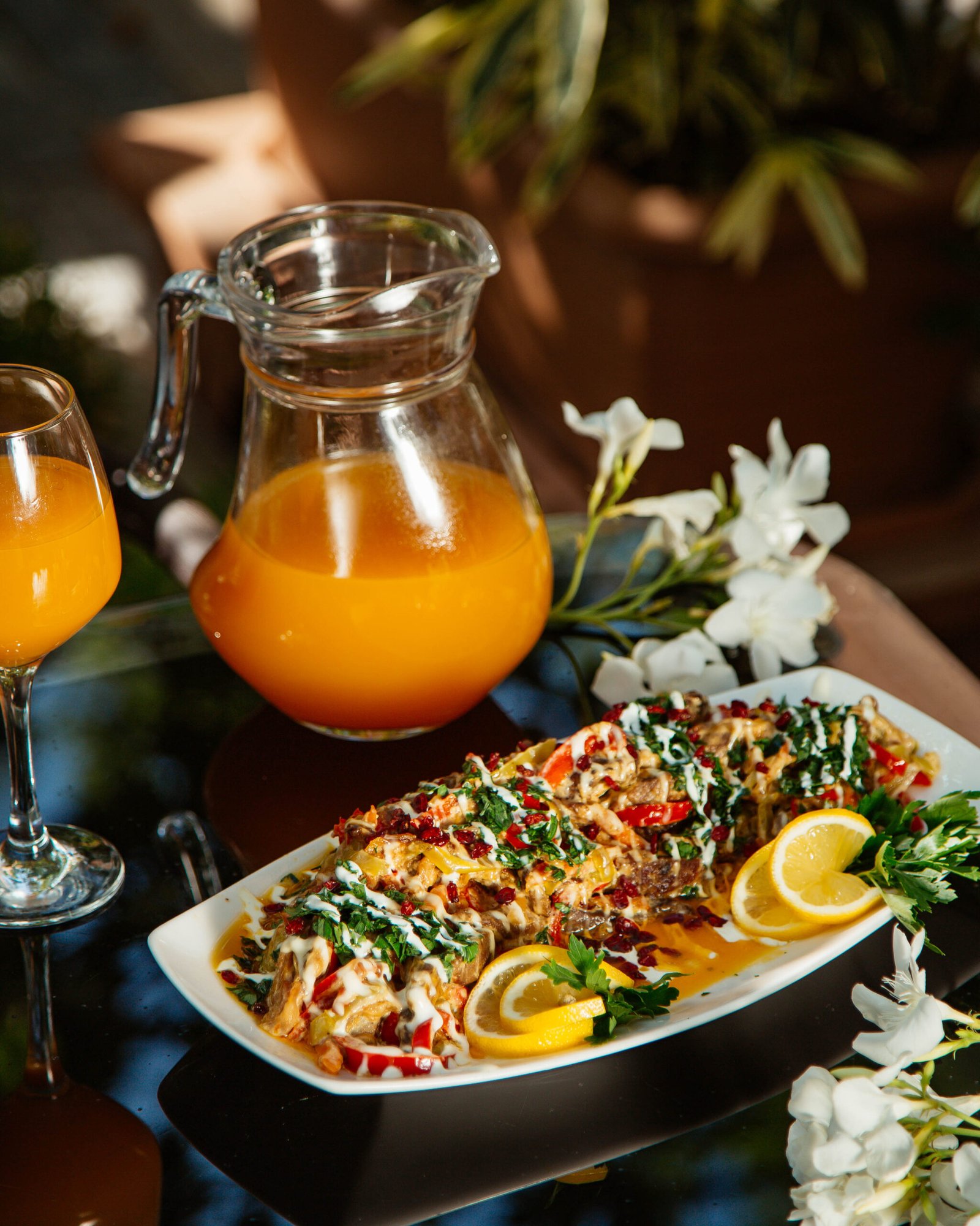 vegetable stew garnished with herbs lemon served with orange juice scaled